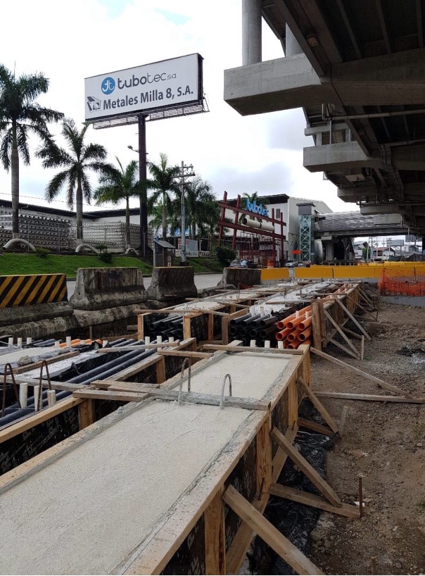 Bancos de ductos y formaletas de cámara eléctrica en obra vial junto a paso elevado