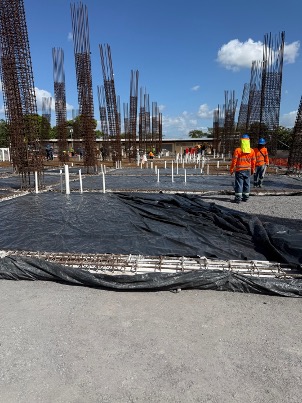 Losa terminada con conduits PVC verticales para puntos eléctricos, operarios verificando
